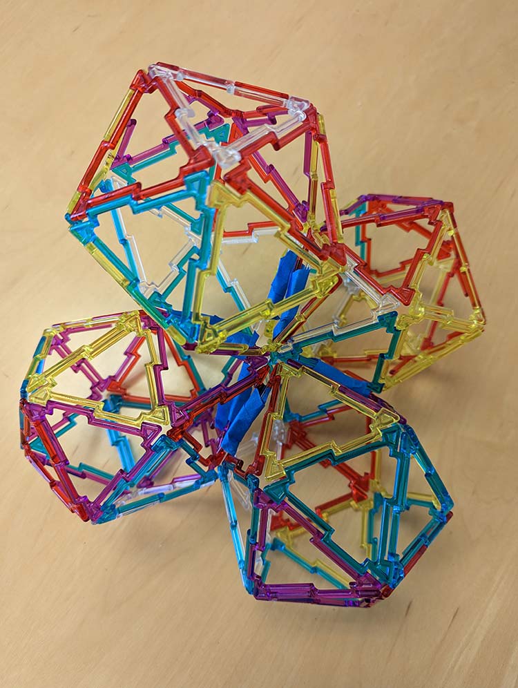 Four icosahedra glued to each other after cutting two edges in each icosahedron, as constructed with Geoshapes and blue painter's tape